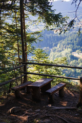 Observation deck on the eco-Hiking trail through the mountains of Bulgaria in the Rhodopes. Wooden benches and a table in the forest with a view of the panorama of the mountains