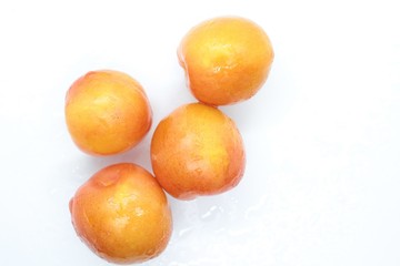 Beautiful delicious orange plums are located on a white background