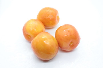 Beautiful delicious orange plums are located on a white background