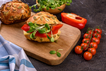 healthy sandwich with microgreens, cheese and pepper close up on dark table