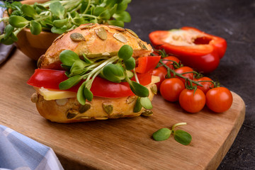 Fototapeta na wymiar healthy sandwich with microgreens, cheese and pepper close up on dark table
