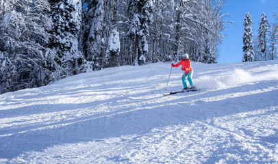 female skier in a bright jacket rides on a ski track. The concept of sport and recreation. Copy space