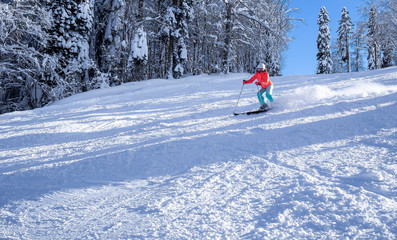 female skier in a bright jacket rides on a ski track. The concept of sport and recreation. Copy space