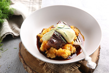 Russian cuisine. The meat with the pumpkin puree with the sauce and herbs on a light background. Background image, copy space