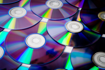 Background CD and DVD discs laid out on a flat surface. Background for saving information. Abstraction.