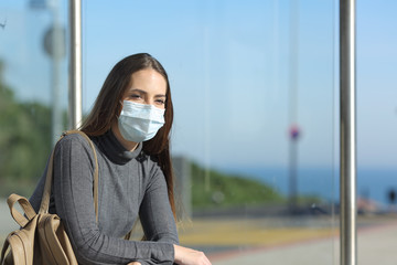 Girl wearing a mask preventing contagion in a bus stop