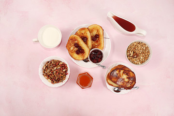 French toasts and granola on a pink table with breadcrumbs. Fried bread with milk and scrambled eggs.. Minimal concept of a modern bakery. Healthy traditional french breakfast.