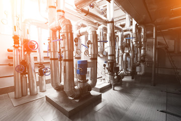 Modern industrial boiler room with pump and pipes for water supply and steam installed. Pumping station. Blue toning with sunflare