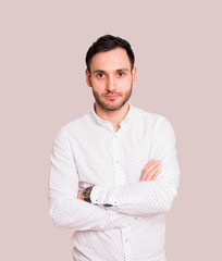 Portrait of a handsome young man. Elegant pose with white dots shirt and crossed arms. Serious expression.