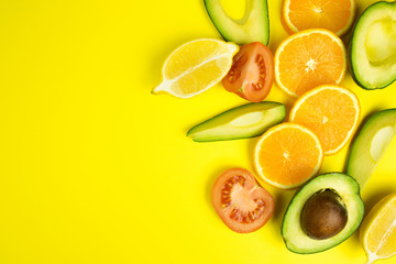 Slice of citrus fruits, oranges, avocados on yellow background