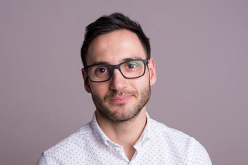 Obraz premium Portrait of a handsome young man with black glasses. Pensive pose.