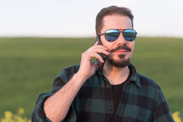 Spring portrait of attractive man in outdoors with sunglasses
