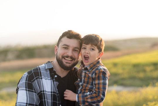 Father and son portrait in outdoors image looking at camera