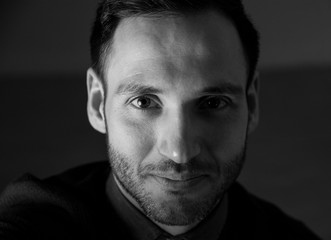 Portrait in black and white of a handsome man looking at camera. Stylish attitude.