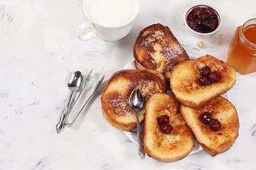French toasts on a gray table with breadcrumbs. Fried bread with milk and scrambled eggs. Top view, place for text. Minimal concept of a modern bakery. Healthy traditional french breakfast.