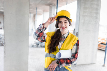 Construction engineer girl with drawings at hand