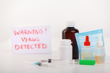 Different pills, syringes, text CORONAVIRUS. 2019 nCoV coronavirus on white background.