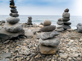 Beutiful image of towers made of balancing rocks on the ocean beach. Concept of harmony and balance
