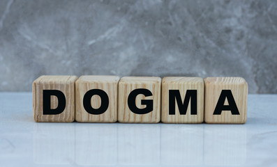 concept word dogma on cubes on a beautiful gray background