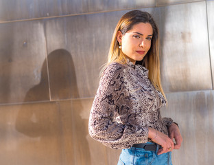 Lifestyle, portrait of a young smiling blonde with leopard shirt, with sun reflections