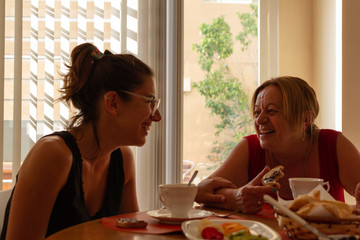 two woman drinking coffee and eating healthy food