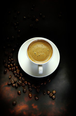 Concetto di bevanda italiana. Tazza bianca classica di caffè espresso con caffè su fondo scuro. Vista dall'alto.