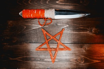 Red pentagram and ritual knife.The pentagram is red. Ancient casket with a mandala. Wooden table...