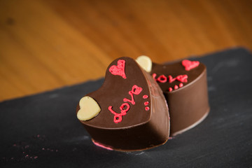 Obraz na płótnie Canvas Two heart-shaped chocolate cakes written LOVE.