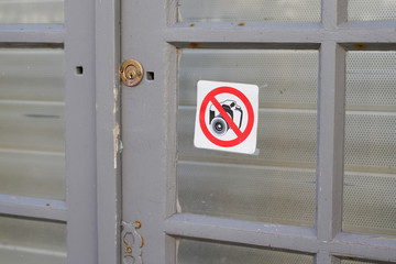 no photos round sign on shop window of city store