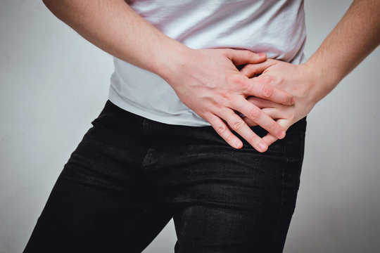 A Man In A White T-shirt Suffers From Pain In His Left Side. The Concept Of Problems With A Stomach Ulcer, Gastritis, Spleen. Toned.