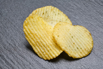 A pair of chips with spices lies on a slate dish. Concept for cafe menu.