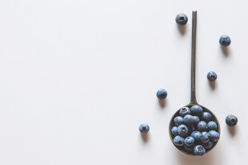 Blueberries in a spoons isolated on a white background. Healthy food, health