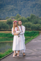 the bride holds the bouquet and groom hugs her by the waist on t