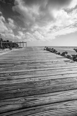 Obraz premium dramatic black and white image of a wooden dock leading to the caribbean coast at Los Patos, Dominican Republic.