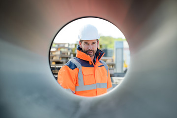 male builder looking through a pipe