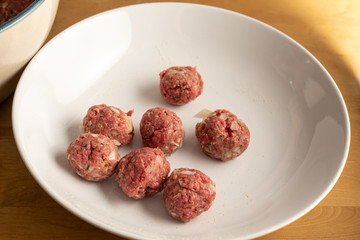 Raw meatballs on a white plate, cooking concept, food preparation