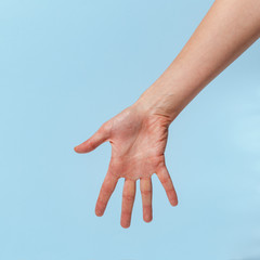 Female hand on a blue background in various positions.