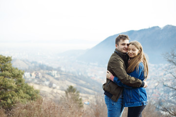 Obraz na płótnie Canvas Happy young couple with a panoramic view in background. Love concept. Relationship happiness.