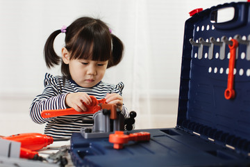toddler girl pretend using DIY tool at home against white backgrround