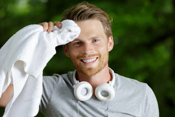 young sporty man wiping his sweat after workout