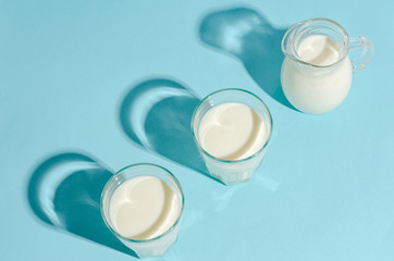 Homemade fermented drink - kefir on a blue background with copy space. Hard shadows.