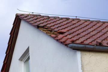 Dachschaden nach Sturm. Kaputte Dachziegel auf einem Haus Dach	