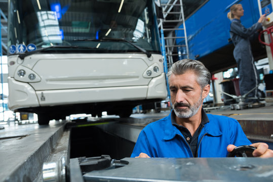 Man Working In Bus Garage