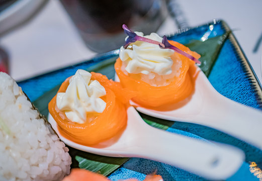 Typical Japanese dish of Guncan flower in a ceramic spoon over a blue dish.