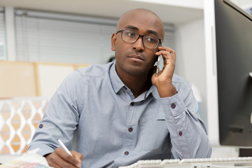 smiling man in office on phone