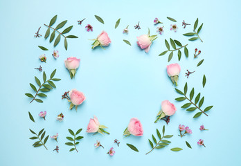 Frame made of beautiful flowers with space for text on light blue background, top view. Floral card design