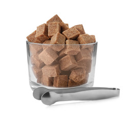 Glass bowl with brown sugar cubes and tongs isolated on white