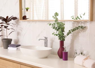 Fototapeta na wymiar Stylish bathroom interior with countertop, mirror and plants. Design idea