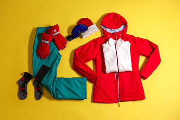 Stylish winter sport clothes on yellow background, flat lay