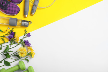 Flat lay composition with spring flowers and sports items on color background. Space for text